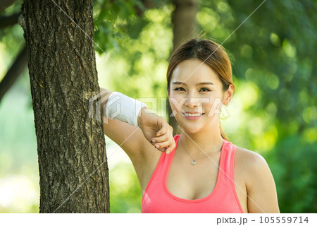 a beautiful woman smiling in her tracksuit in the park a beautiful woman smiling in her tracksuit in the park 105559714