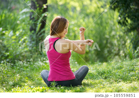young woman doing yoga in park 105559851