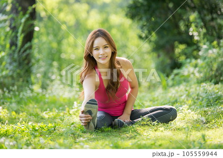 young woman doing yoga in park 105559944