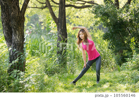 young woman doing yoga in the park 105560146