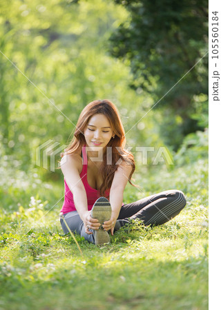 young woman doing yoga in the park 105560184