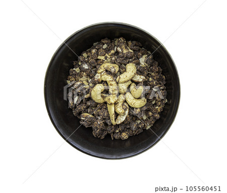 Homemade malt flakes cereal consists of rolled oats, cashew nuts, seeds, and honey in ceramic bowl isolated on white background with clipping path. Homemade malt flakes cereal consists of rolled oats, cashew nuts, seeds, and honey in ceramic bowl isolated on white background with clipping path. 105560451