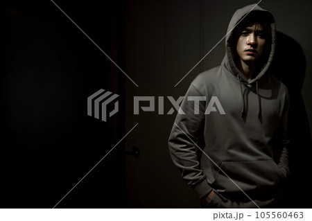 グレーのパーカーを着て暗闇に立つ不良少年 AI generated グレーのパーカーを着て暗闇に立つ不良少年 AI generated 105560463