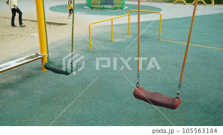 Two swings in an outdoor park playground 105563184