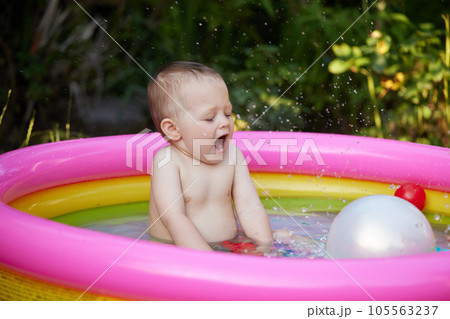 cute baby girl swimming in kid inflatable pool 105563237