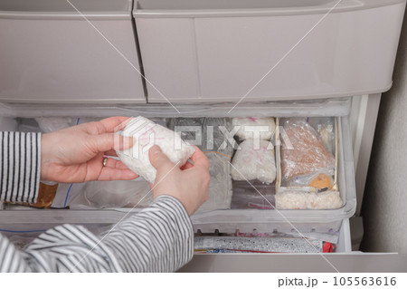 【冷凍室から冷凍ごはんを出す主婦】 105563616
