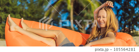 Summer lifestyle portrait of pretty girl sitting on the orange inflatable sofa on the beach of tropical island. Relaxing and enjoying life on air bed BANNER, LONG FORMAT Summer lifestyle portrait of pretty girl sitting on the orange inflatable sofa on the beach of tropical island. Relaxing and enjoying life on air bed BANNER, LONG FORMAT 105564281