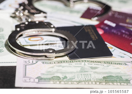 Steel handcuffs and credit cards lying on the background of American dollars. 105565587