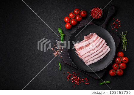 Fresh raw bacon cut into slices with salt, spices and herbs Fresh raw bacon cut into slices with salt, spices and herbs 105565759