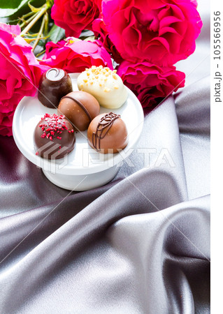 Gourmet chocolate with pink garden roses on silver silk. 105566956