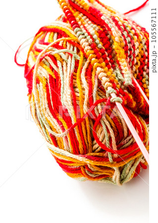 Knitting with multi colored yarn with orange, red, and yellow tones. 105567111
