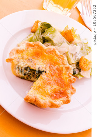 Individual spinach quiche served with salad. 105567252