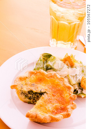 Individual spinach quiche served with salad. 105567272