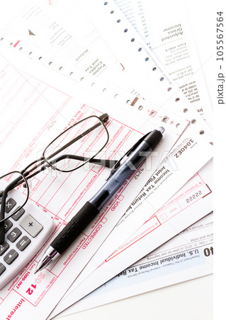 Calculating numbers for income tax return with pen and calculato 105567564