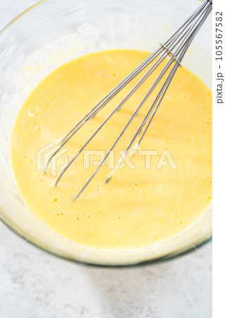 Close up view. Close up view. Mixing ingredients in a glass mixing bowl to bake funfettti bundt cake. Close up view. Close up view. Mixing ingredients in a glass mixing bowl to bake funfettti bundt cake. 105567582
