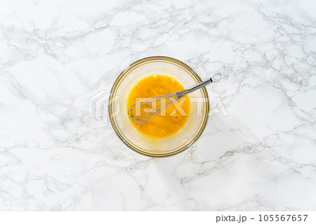 Flat lay. Mixing ingredients in a large glass mixing bowl to bake peppermint white chocolate cookies. 105567657