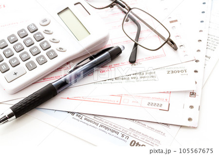Calculating numbers for income tax return with pen and calculato Calculating numbers for income tax return with pen and calculato 105567675