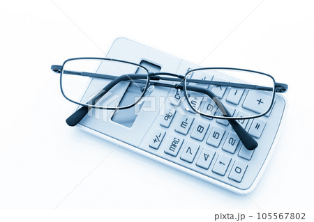 Simple yellow calculator with reading glasses on a white background. 105567802