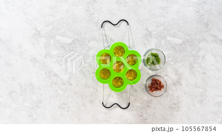Flat lay. Filling silicone molds with egg mixture to make egg bites in a pressure cooker. Flat lay. Filling silicone molds with egg mixture to make egg bites in a pressure cooker. 105567854