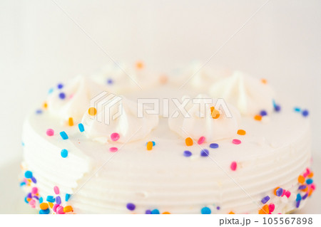 White little birthday cake with funfetti sprinkles on a white cake plate. 105567898