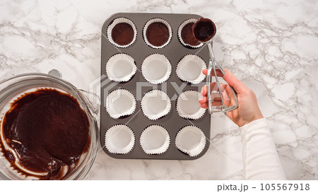 Flat lay. Step by step. Baking chocolate cupcakes. Scooping chocolate cupcake batter into a cupcake pan. Flat lay. Step by step. Baking chocolate cupcakes. Scooping chocolate cupcake batter into a cupcake pan. 105567918