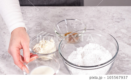 Step by step. Ingredients in a glass mixing bowl to prepare cream cheese frosting. 105567937