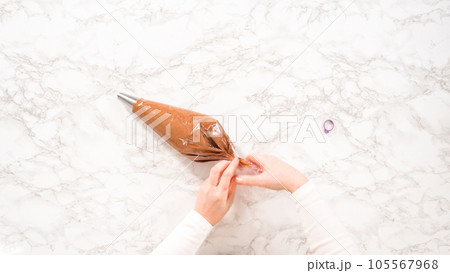 Flat lay. Step by step. Chocolate ganache frosting in a piping bag with a metal tip. Flat lay. Step by step. Chocolate ganache frosting in a piping bag with a metal tip. 105567968