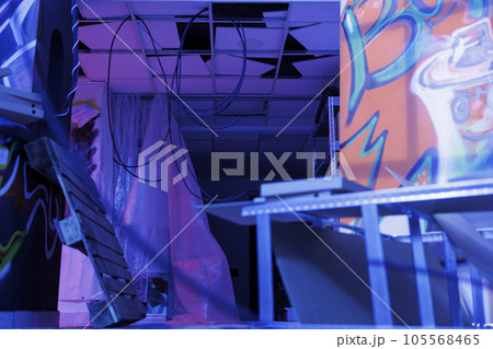 Destroyed old space with bright lights turned into ruin, deserted urban ghetto glowing in the darkness of disintegration. Neglected abandoned place with fluorescent purple light. Destroyed old space with bright lights turned into ruin, deserted urban ghetto glowing in the darkness of disintegration. Neglected abandoned place with fluorescent purple light. 105568465