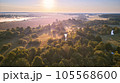 Aerial summer sunrise view. Rural landscape, river meandering in forest green trees. Morning Misty Scene. Serene atmosphere fog panorama. Agriculture fields, wood on riverbank 105568600