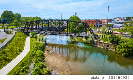 Summer aerial of river in Mount Vernon Ohio with metal walking bridge drone shot 105569983