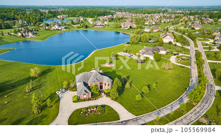 Textured techno road through expensive neighborhood property fresh cut grass homes near pond 105569984