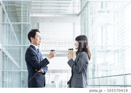仕事の休み時間に飲み物を飲むビジネスマン男女 仕事の休み時間に飲み物を飲むビジネスマン男女 105570419