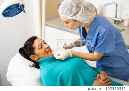 Woman getting procedure of lip augmentation in clinic Woman getting procedure of lip augmentation in clinic 105570582