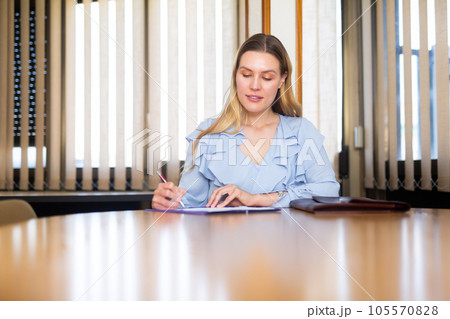 Business woman in office interior filling up documents Business woman in office interior filling up documents 105570828