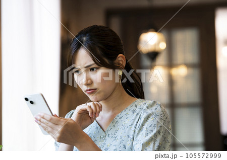 カフェでスマホを操作する女性 カフェでスマホを操作する女性 105572999