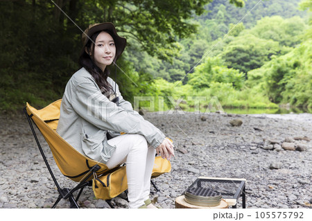 河原でチェアリングをする若い女性 河原でチェアリングをする若い女性 105575792