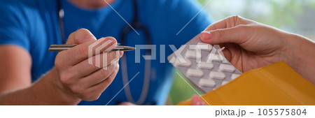 Pharmacist explains prescription to client with medicinal pills. 105575804