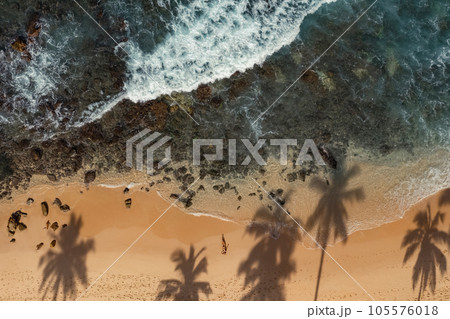 Top Aerial View of Tanned Woman in Bikini on the Rocky Beach on Summer Weekend Vacation Top Aerial View of Tanned Woman in Bikini on the Rocky Beach on Summer Weekend Vacation 105576018