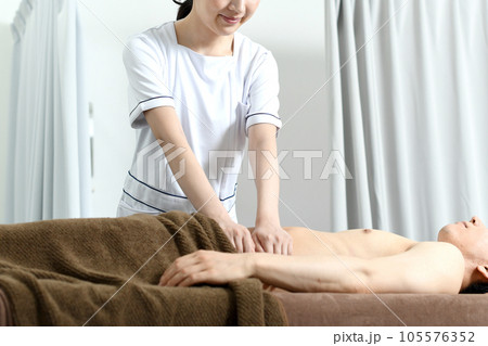 お腹の痩身マッサージをする女性セラピスト 105576352