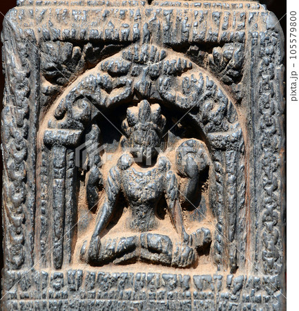 Small carved sitting Buddha on a wooden column in Nepal 105579800