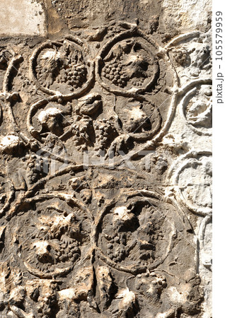 Detail of carved stone with grape 105579959