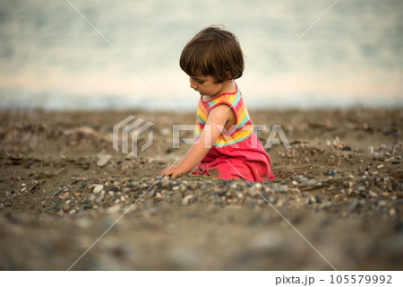 Toddler baby playing on a beach 105579992