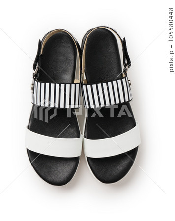 Black and white leather women's sandals. A new pair of shoes on a white background. Black and white leather women's sandals. A new pair of shoes on a white background. 105580448