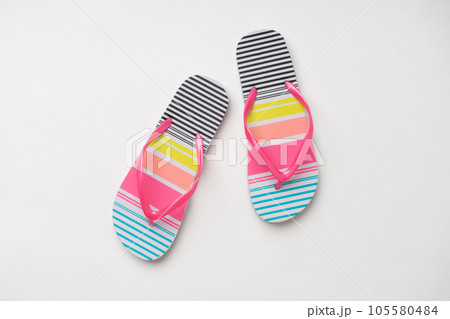 Beach slippers with colorful stripes. A new pair of shoes on a white background. 105580484