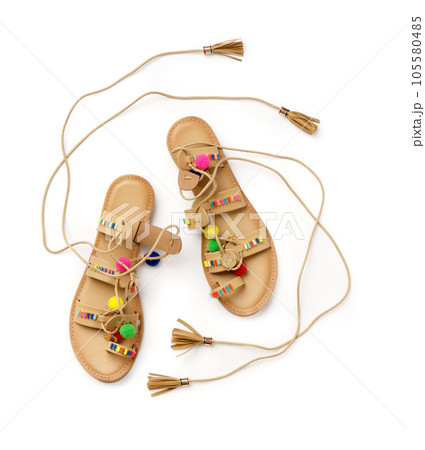 Beach women's leather lace-up sandals. A new pair of shoes on a white background 105580485