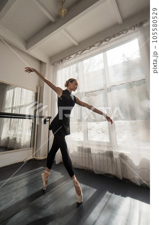 A beautiful Asian ballerina is training in a dance class. Vertical photo. A beautiful Asian ballerina is training in a dance class. Vertical photo. 105580529