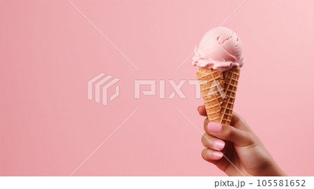 Hand-holding strawberry ice cream cone in pink faded pastel color Hand-holding strawberry ice cream cone in pink faded pastel color 105581652