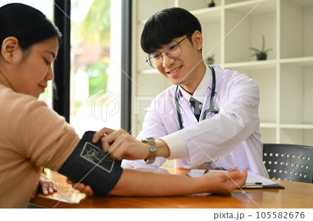 Doctor giving recommendations and measuring blood pressure female patient. Medical and health care concept. 105582676
