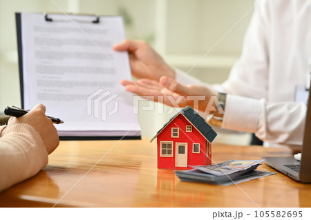 Male realtor explaining contract details to clients at meeting. Mortgage, real estate and property concept. 105582695