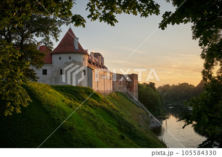View of latvian tourist landmark attraction - ruins of medieval Bauska castle and the remains of a later palace at sunset. Bauska city, Latvia. 105584330